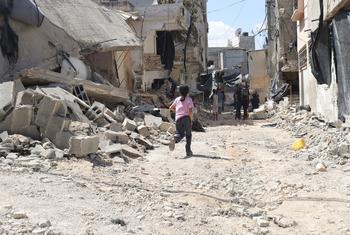 A young girl runs through the rubble of damaged buildings after an Israeli military raid at Nur Shams refugee camp, in the West Bank in August 2024. 