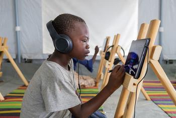 Children participate in an e-learning session at the Al Seniyaa internally displaced people’s gathering site in Port Sudan.