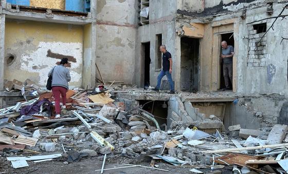 People survey the damage caused by a missile attack on a building in Kharkiv City, Ukraine.