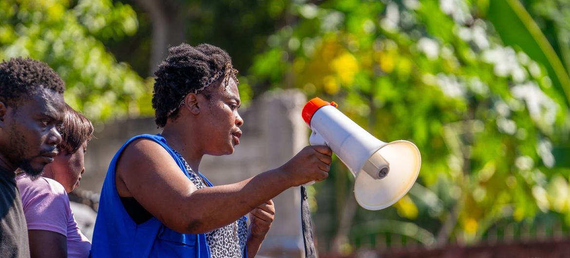 IOM staff member, Rose, supports displaced people as they pick up humanitarian supplies.