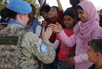 A peacekeeper greets the students of the Faouar School in Syria which was one of the four schools that was refurbished by the UN Disengagement Force.