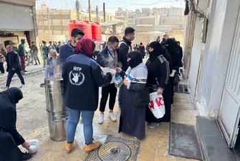 People in Aleppo, Syria, receive hot meals from WFP staff.