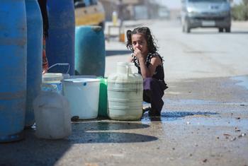 A young girl sits next to a water trucking point in Hasakah city, northeast Syria.