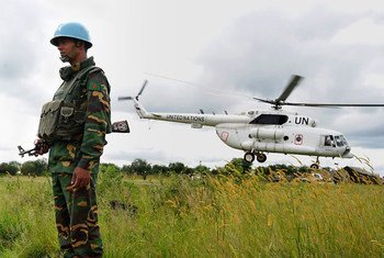 A UN peacekeeper in South Sudan with one of the mission's helicopters.