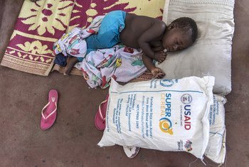 A young boy in Mozambique sleeps next to a bag of food aid donated by USAID and distributed by the UN’s World Food Programme.